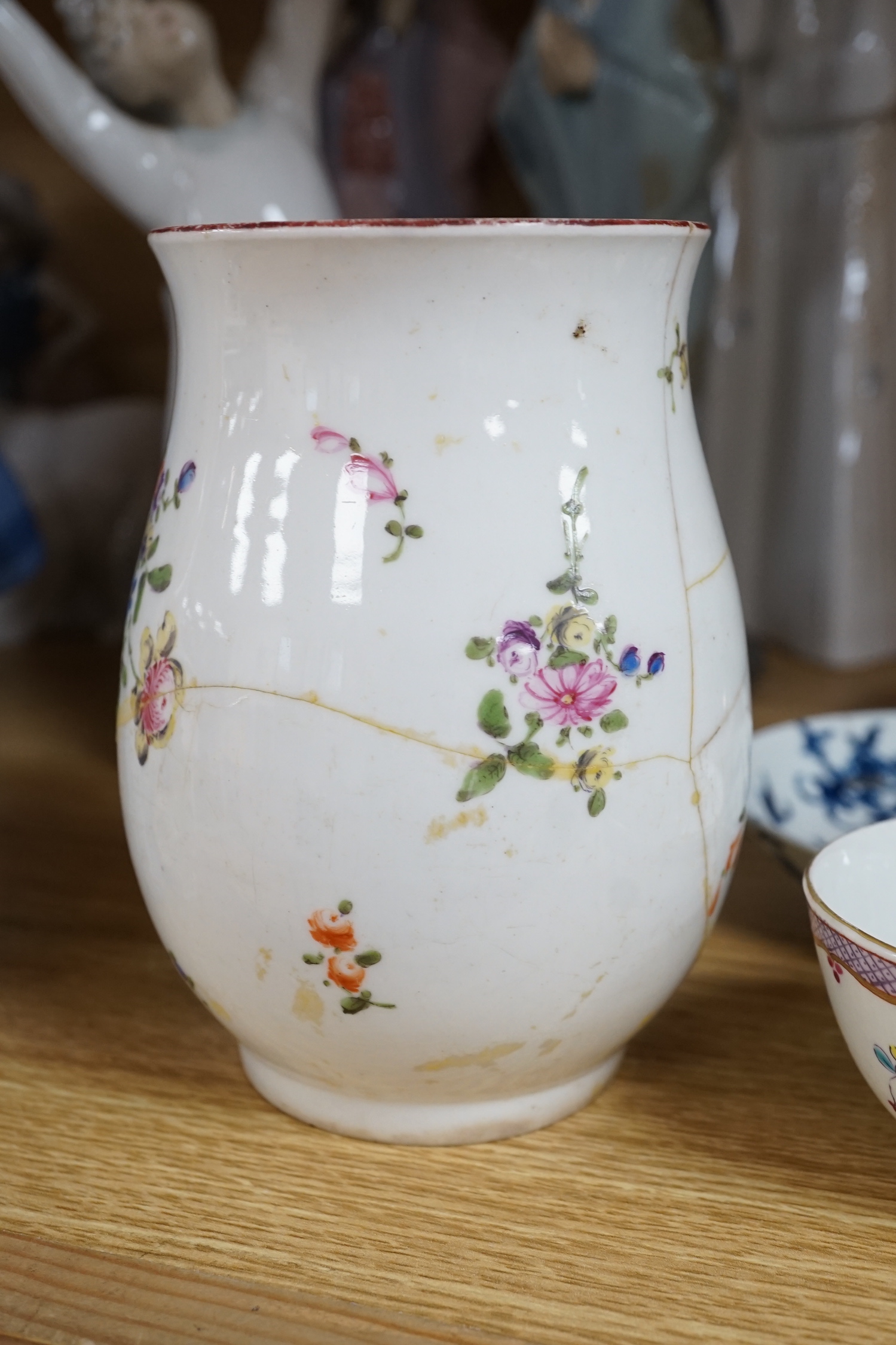A Chelsea ecuelle base with twig handles painted with Meissen style flowers, red anchor mark, a Derby mug painted with flowers and scattered sprigs, a Coalport mug in the Chinese export style, a Caughley leaf shaped pick